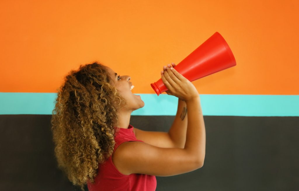 Mix race women shouting into megaphone